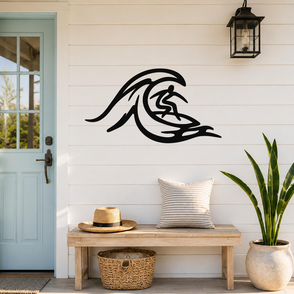 Black metal surfer wall art with wave cutout design, mounted on a white shiplap wall above a wooden bench in a porch entryway.