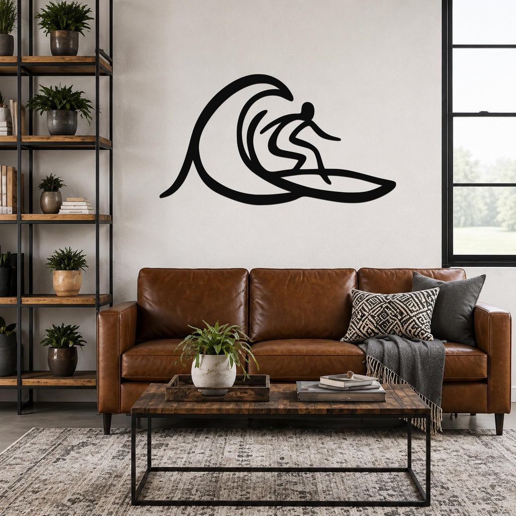 Black metal wall art of a surfer silhouette riding a wave, mounted above a brown leather sofa in a living room.