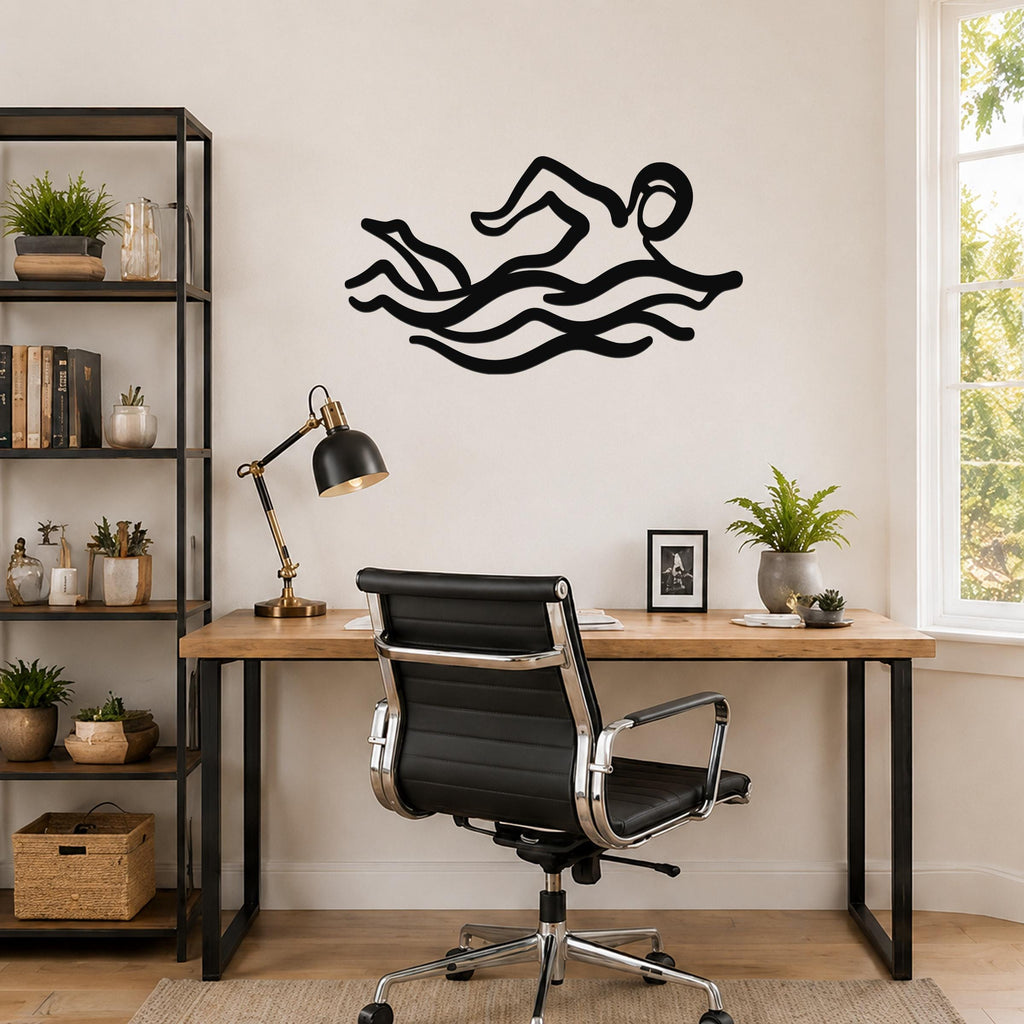 Black metal swimmer wall art with motion-line cutouts, mounted above a wooden desk in a home office.