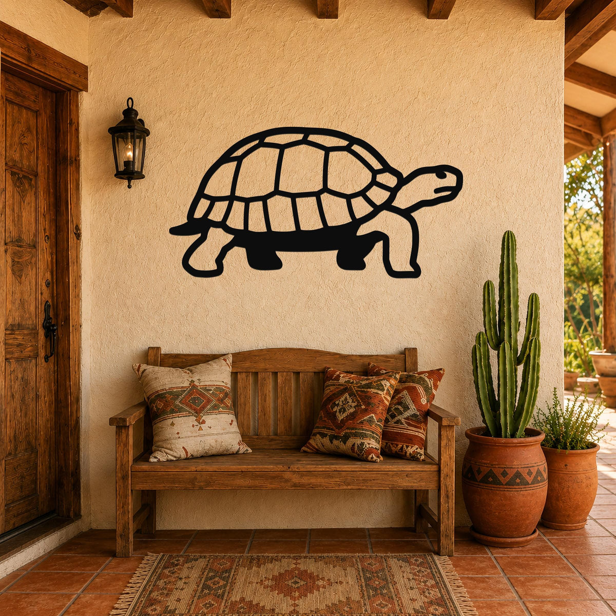 Black metal tortoise wall art with detailed shell cutouts, mounted on a stucco wall above a wooden bench in a patio entryway.