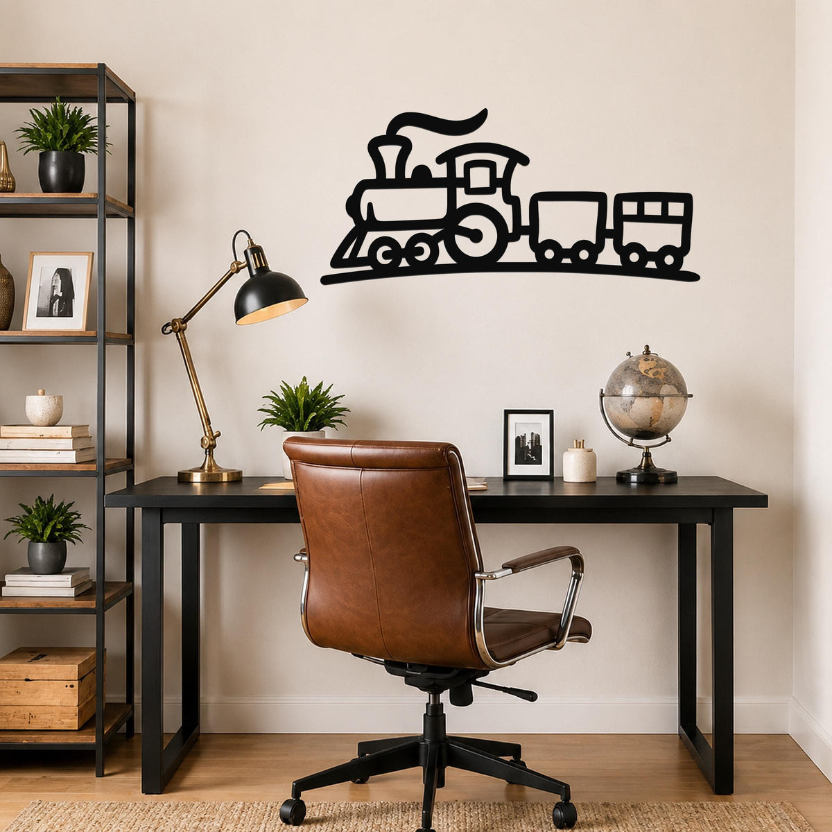 Black metal train wall art silhouette with smoke and wheels, mounted above a black desk in a home office.