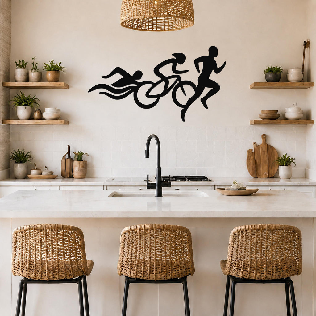 Black metal triathlon wall art with swim, bike, and run silhouettes, mounted above a kitchen counter.