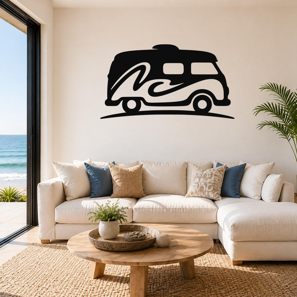 Black metal wall art silhouette of a vintage camper van with wave design, mounted above a white sofa in a living room with ocean view.