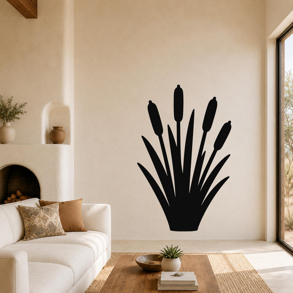 Black metal cattail wall art silhouette with multiple reed stems and leaves, mounted on a living room wall above a white sofa.