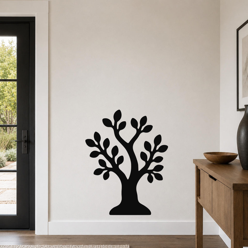 Black metal wall art in the shape of a tree with leafy branches, mounted on a light-colored wall above a wooden console table in a modern entryway.