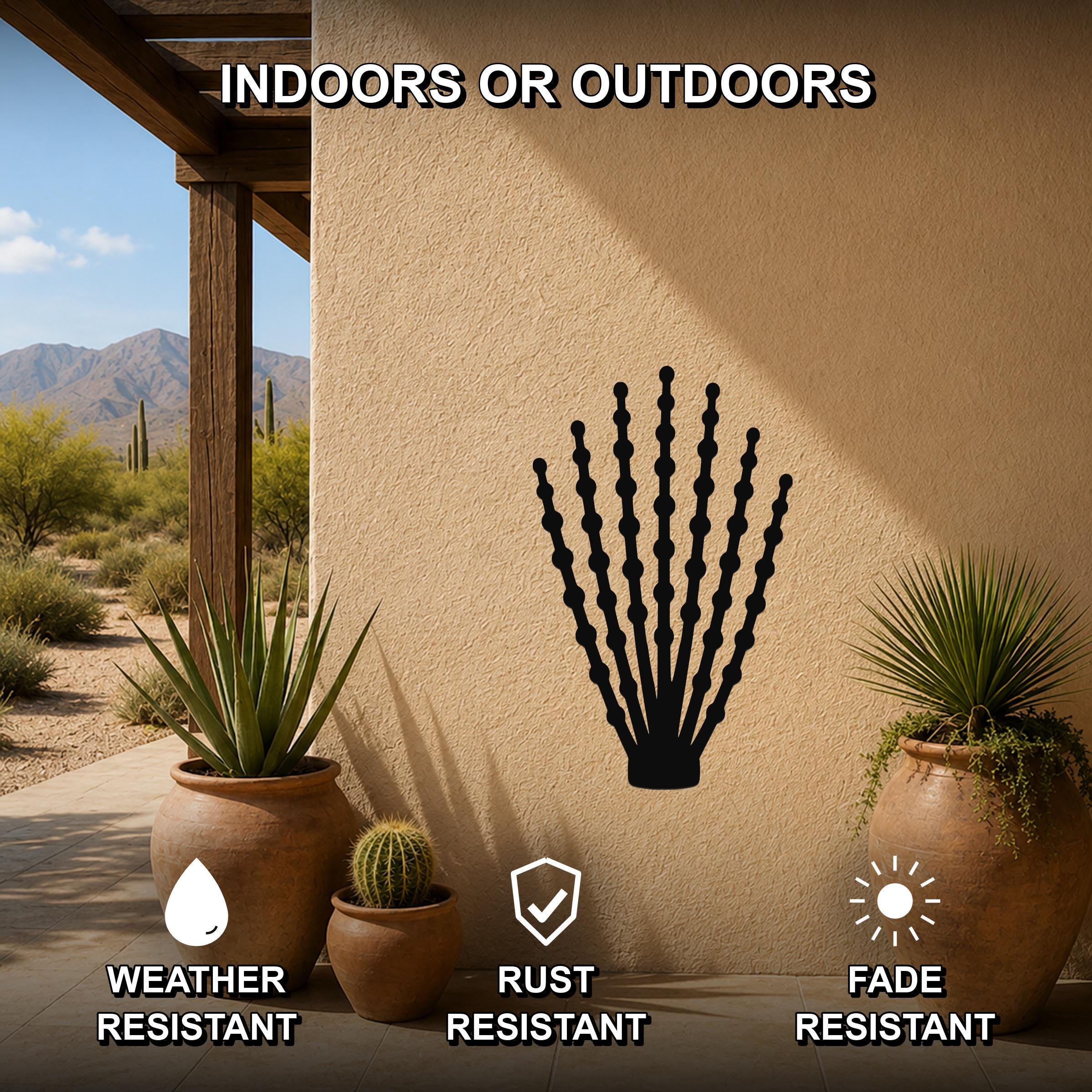 Black metal ocotillo wall art with beaded branch cutouts, mounted on an outdoor stucco wall between potted plants on a patio.