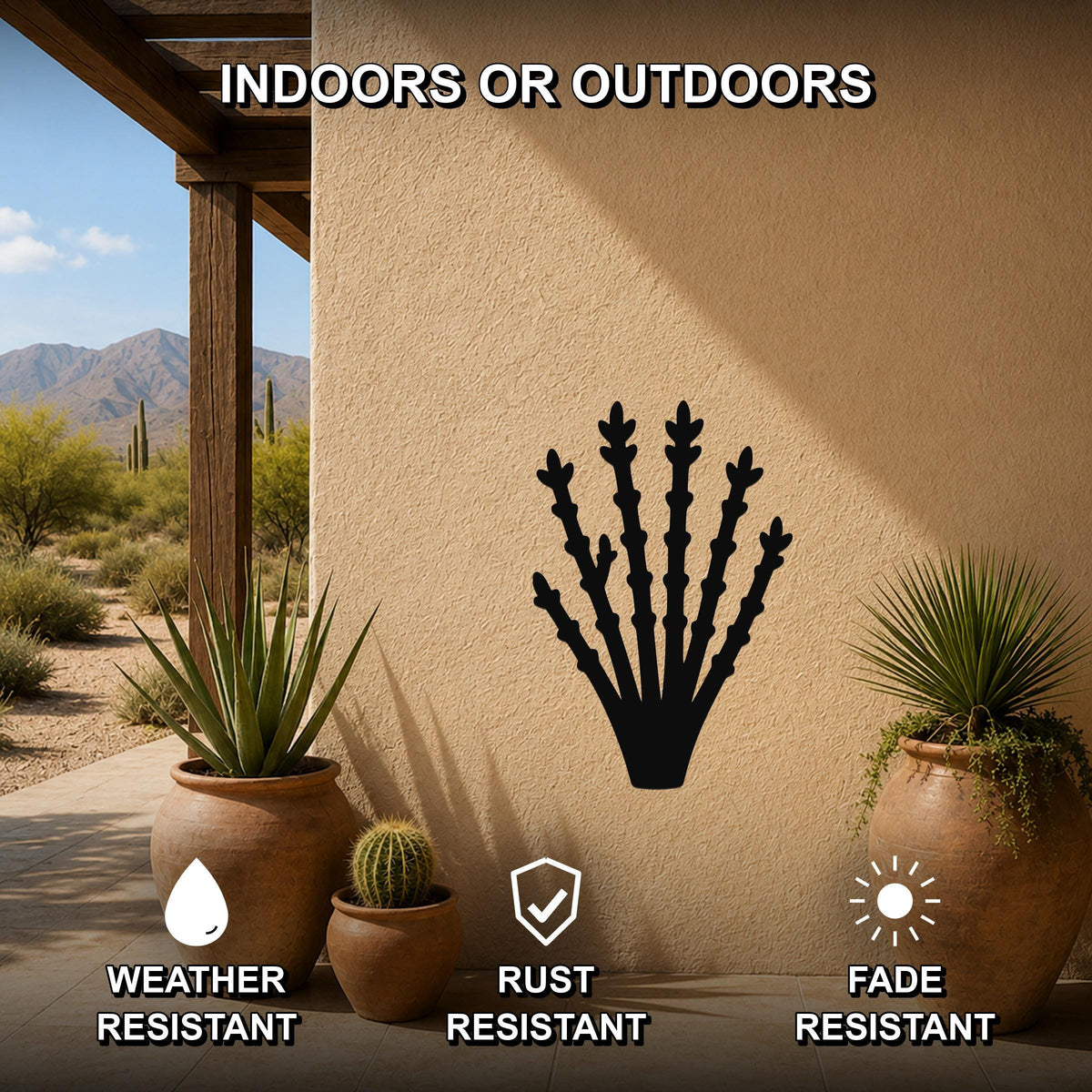 Black metal ocotillo wall art silhouette mounted on an outdoor stucco wall, displayed on a patio with potted desert plants and a mountain view.