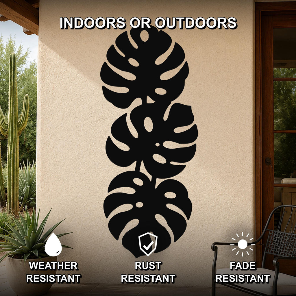 Black metal monstera leaf wall art with three stacked tropical leaf cutouts, mounted on an outdoor patio wall, weather resistant, rust resistant, and fade resistant.