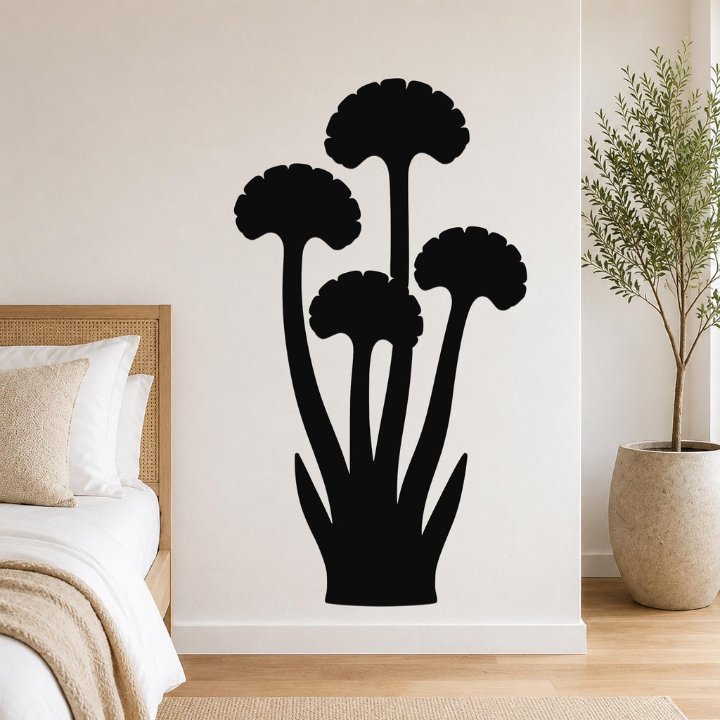 Black metal wall art featuring a ginkgo leaf silhouette with multiple stems and fan-shaped leaves, mounted on a bedroom wall above a bed.