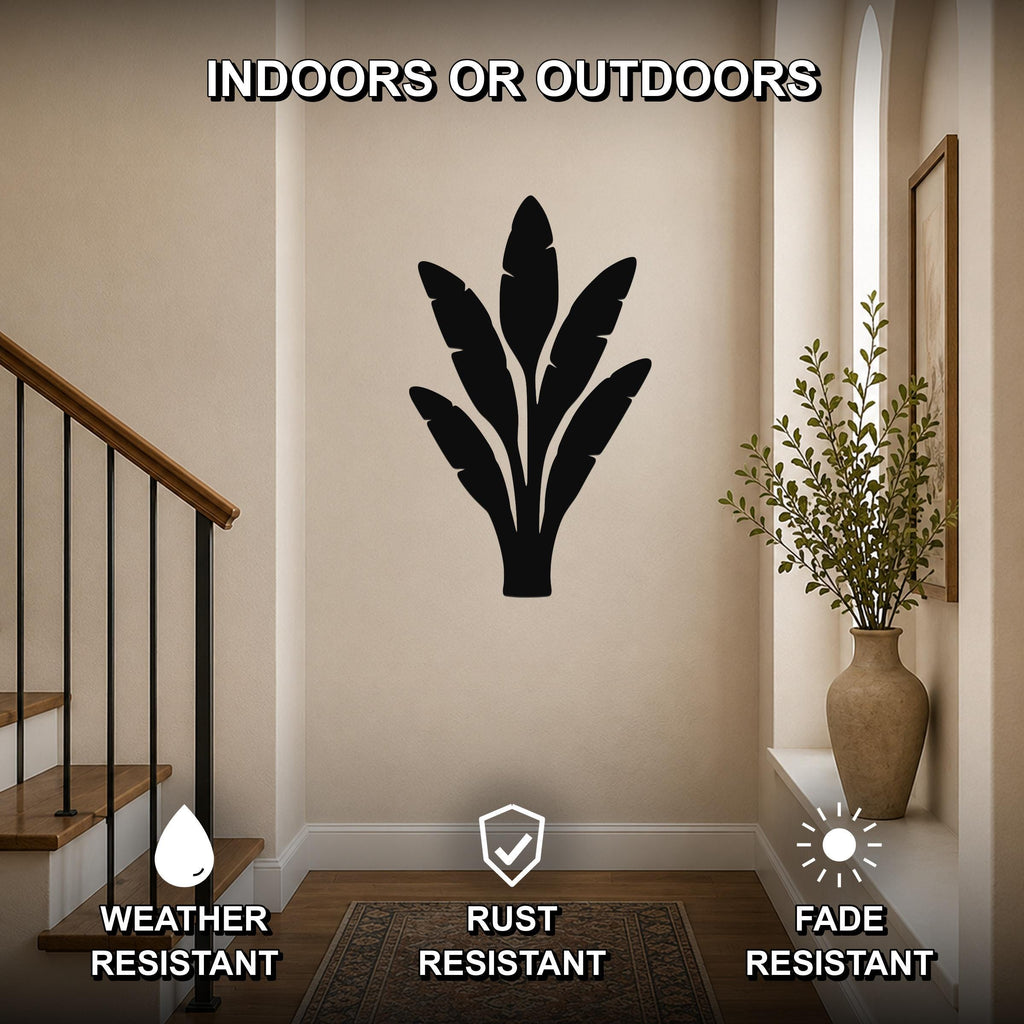 Black metal banana plant wall art with leaf cutouts, mounted on a hallway wall near a staircase and vase, suitable for indoor or outdoor use.
