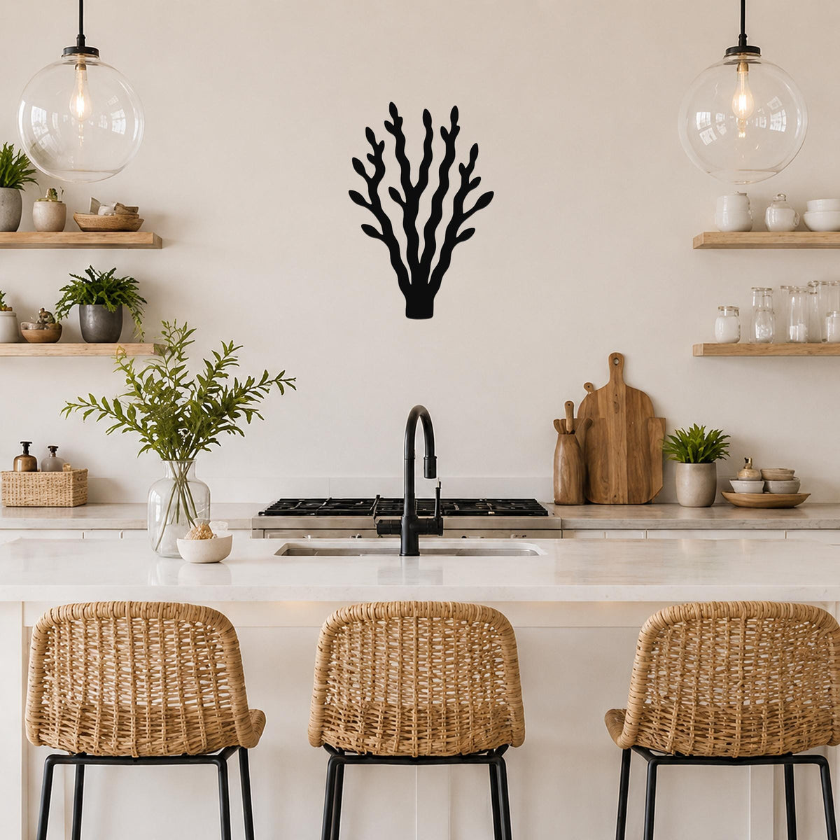 Black metal kelp wall art with branching cutouts, mounted on a kitchen wall above a counter between two glass pendant lights.