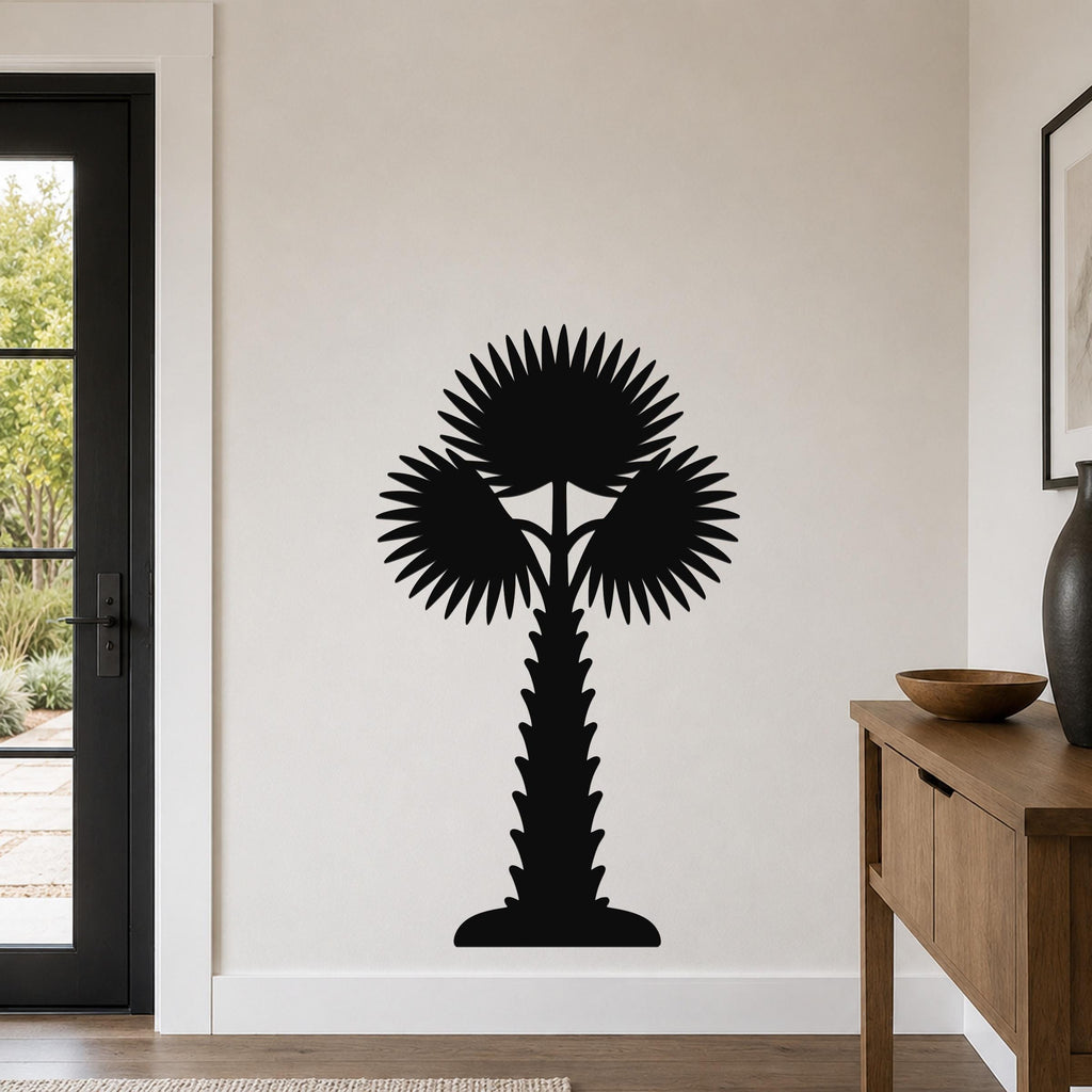 Black metal palm tree wall art with fan-shaped fronds and a textured trunk, mounted on a white wall in a modern entryway.