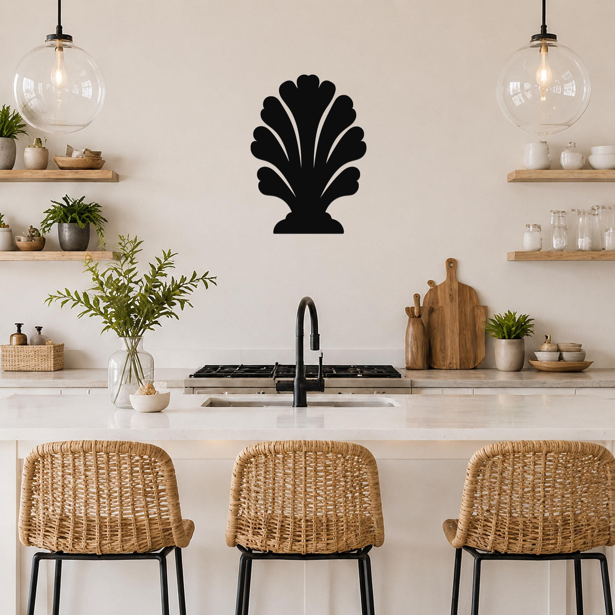 Black metal shell wall art with scalloped cutouts, mounted on a kitchen wall above a counter between two glass pendant lights.
