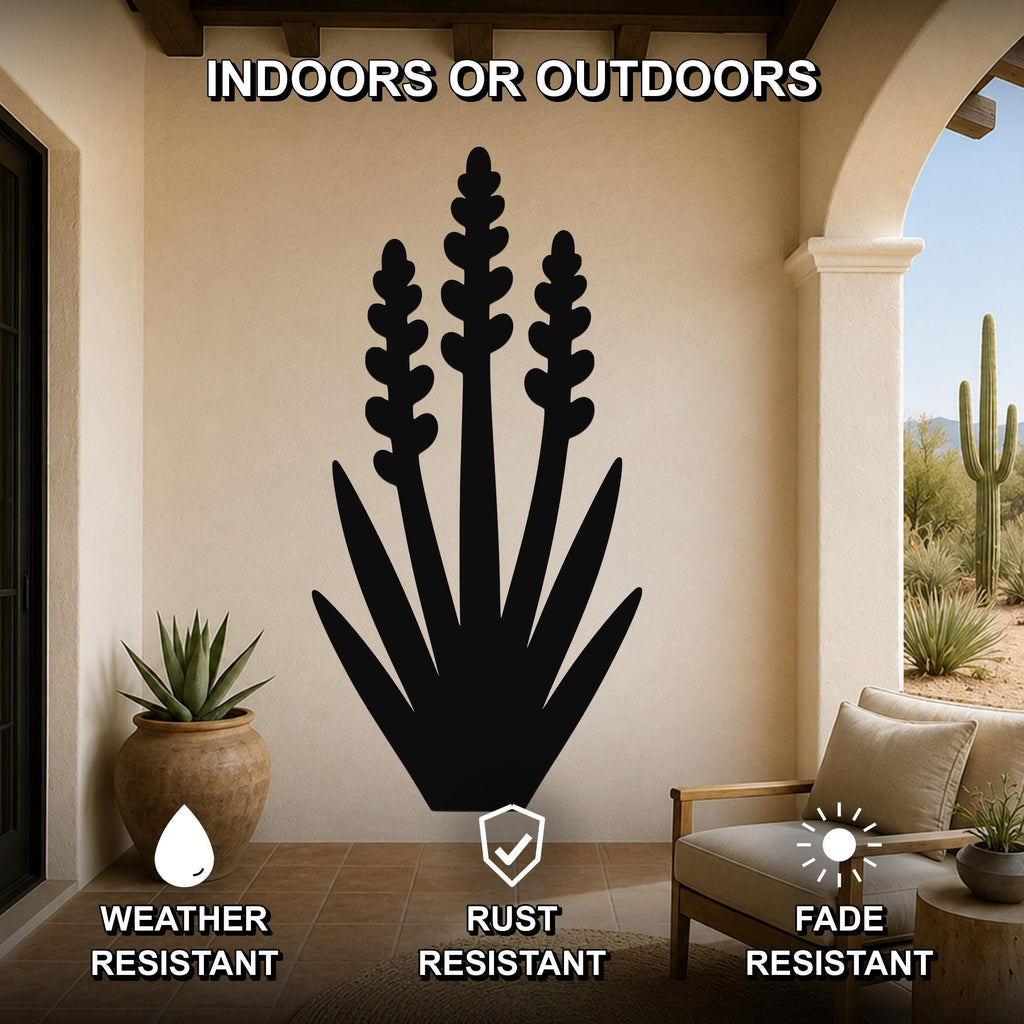 Black metal yucca wall art with layered leaf and bloom cutouts, mounted on a beige patio wall above a chair, weather resistant, rust resistant, and fade resistant.