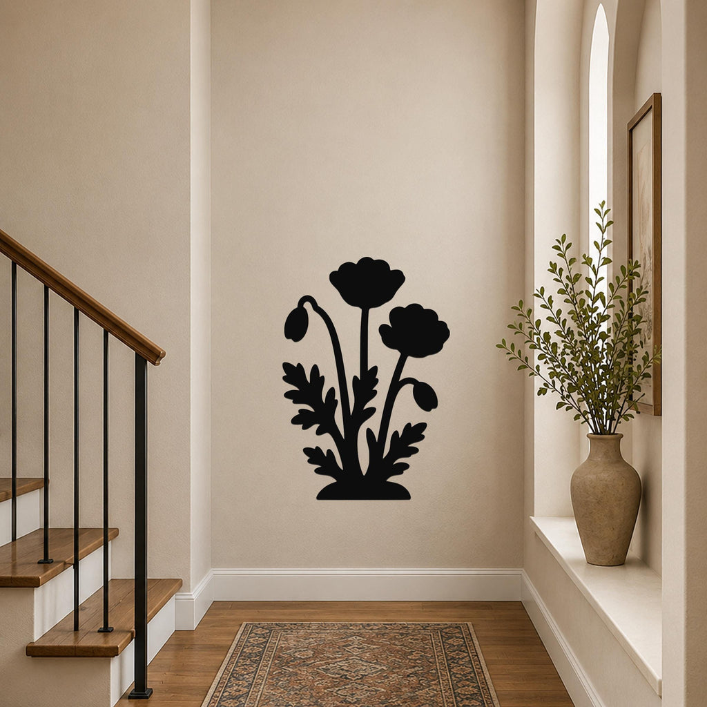 Black metal wall art with a floral silhouette of three poppies and leaves, mounted on a hallway wall near a staircase and a window with a potted plant.