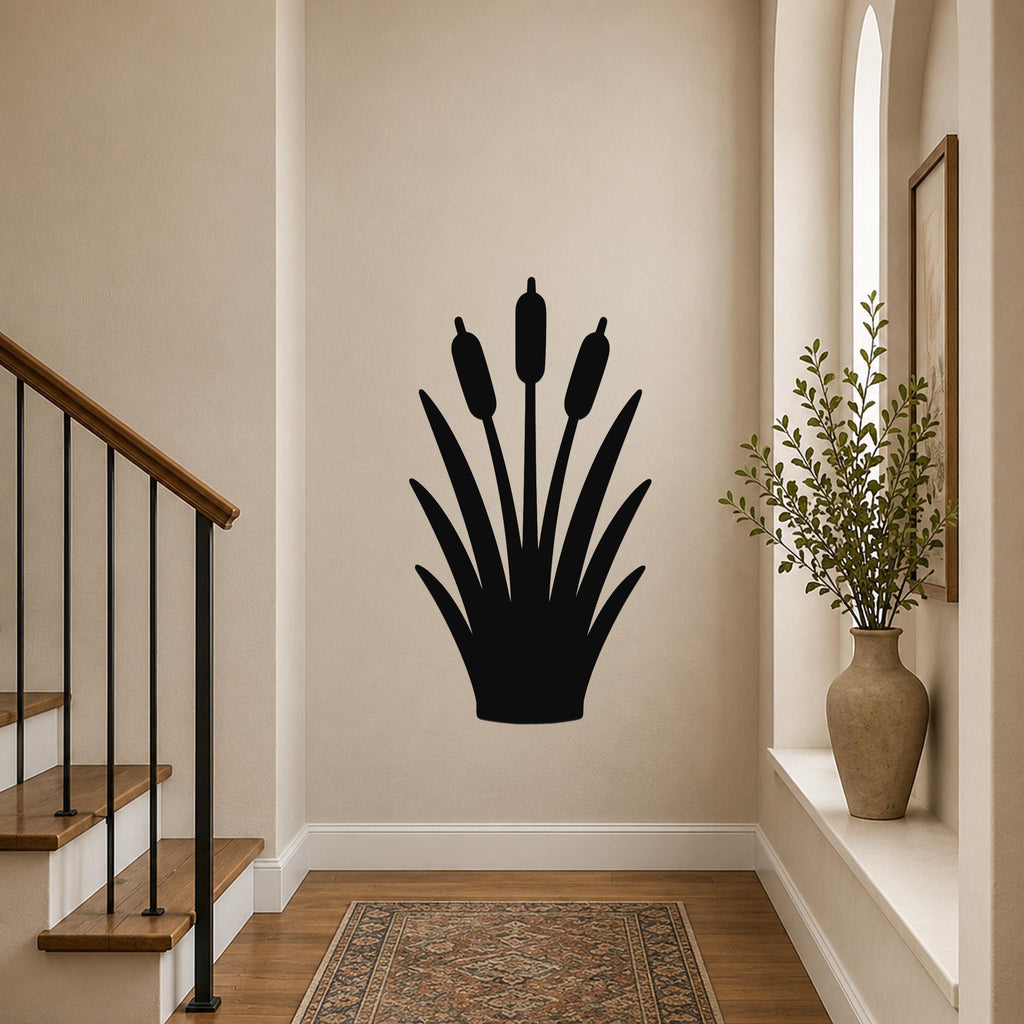 Black metal cattail wall art silhouette with three seed heads and leafy base, mounted on a hallway wall near a staircase and window.