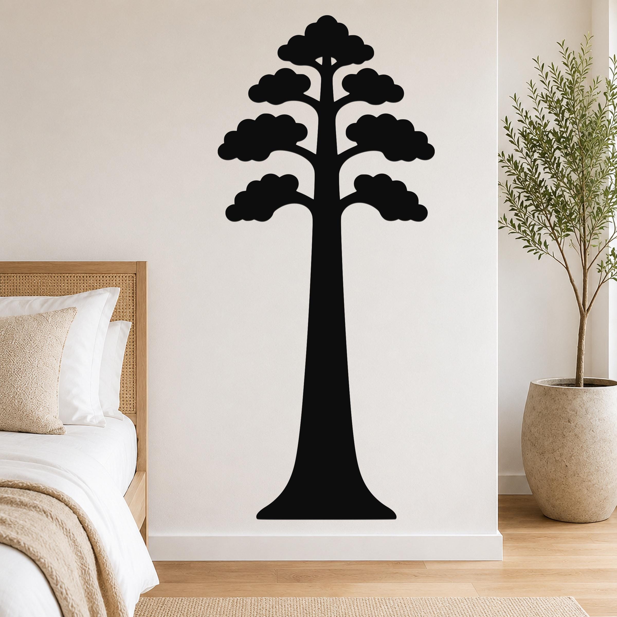 Black metal sequoia tree wall art with layered canopy cutouts, mounted on a bedroom wall above a bed.