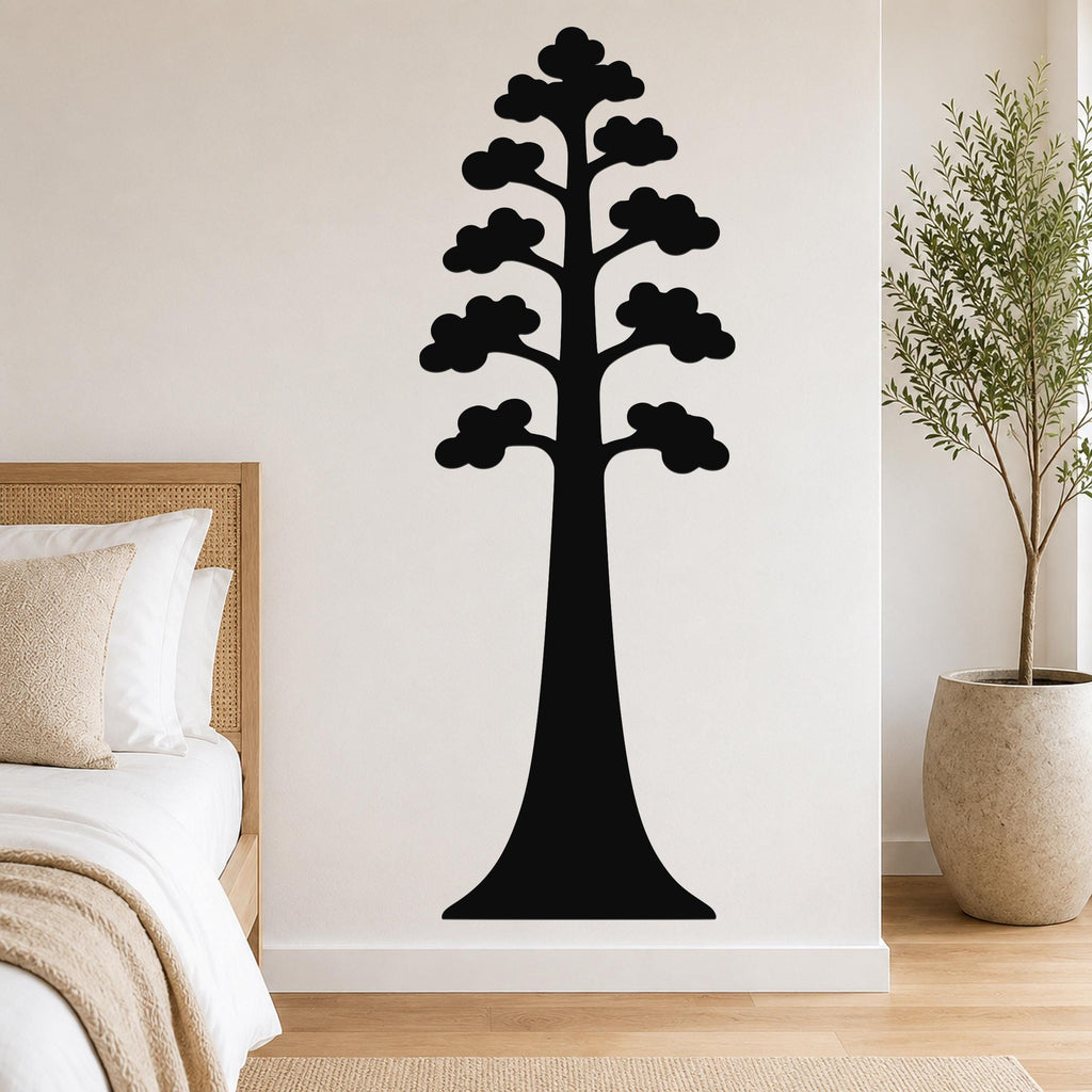 Black metal wall art in the silhouette of a sequoia tree with layered cloud-like branches, mounted on a white wall above a bed in a bedroom.
