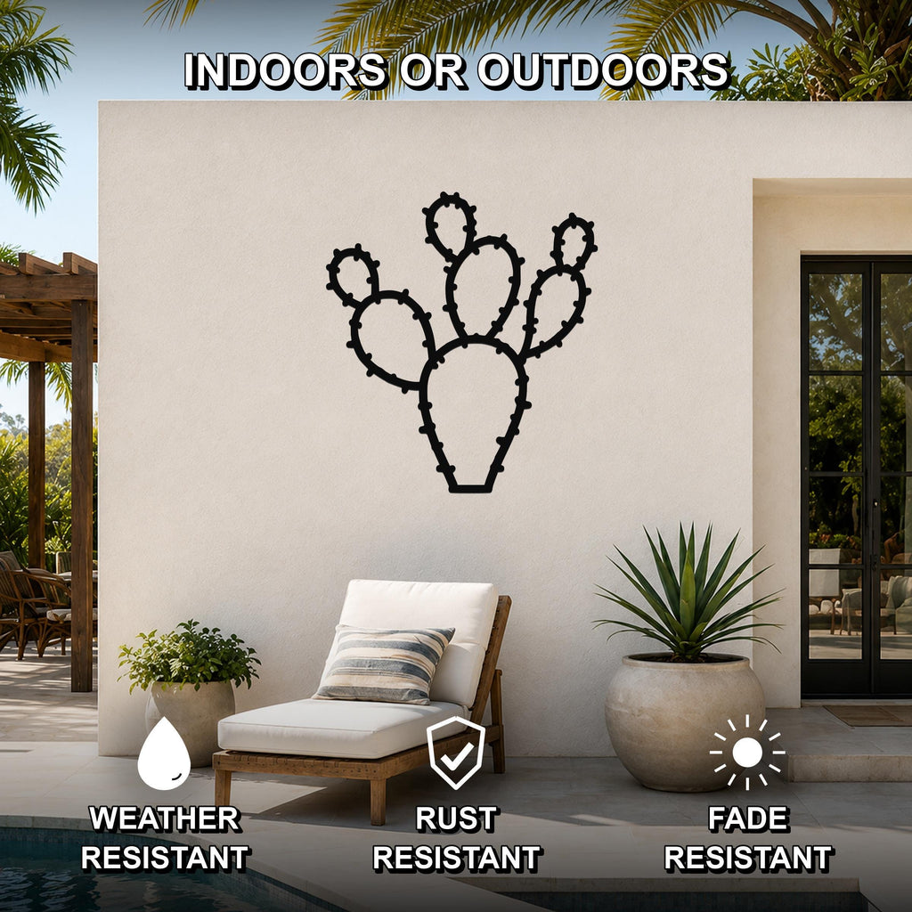 Black metal prickly pear cactus wall art with detailed spine cutouts, mounted on an outdoor patio wall above a lounge chair.