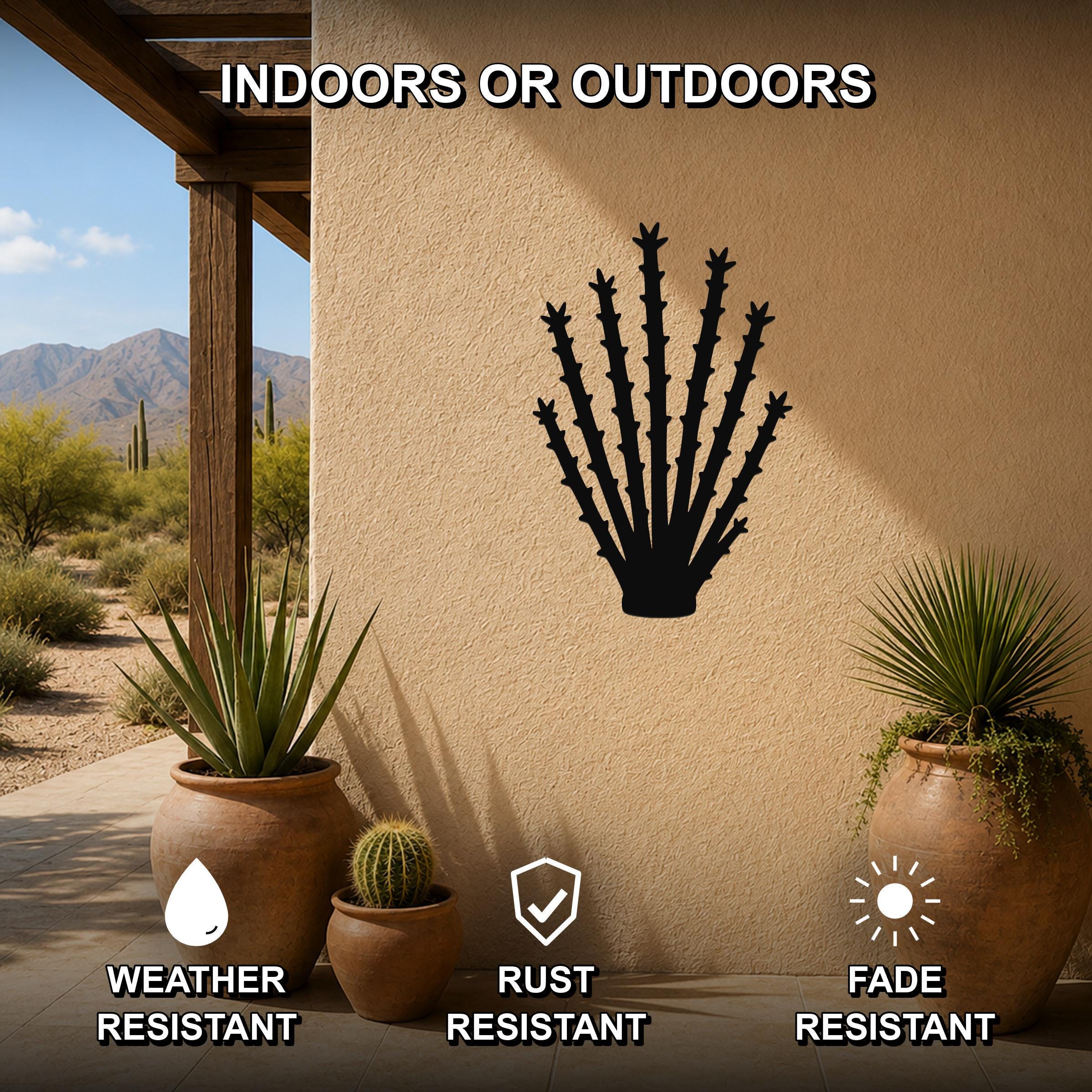 Black metal ocotillo wall art silhouette mounted on a beige outdoor wall, displayed on a patio with potted plants and desert scenery in the background.