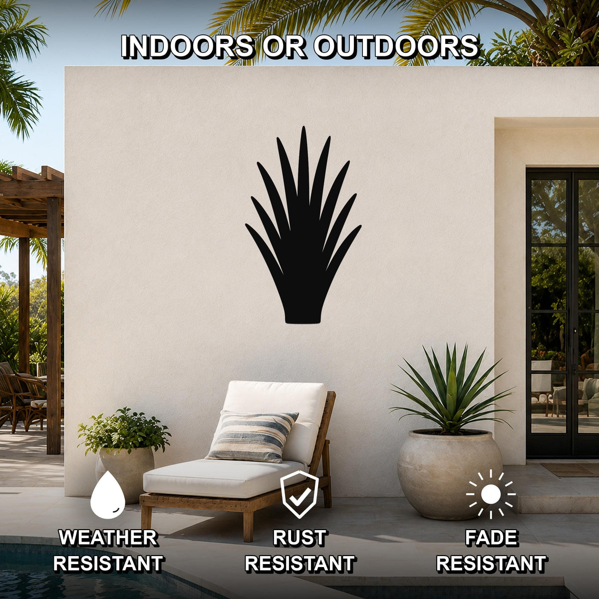 Black metal abstract desert plant wall art with spiky silhouette, mounted on an outdoor patio wall above a lounge chair.