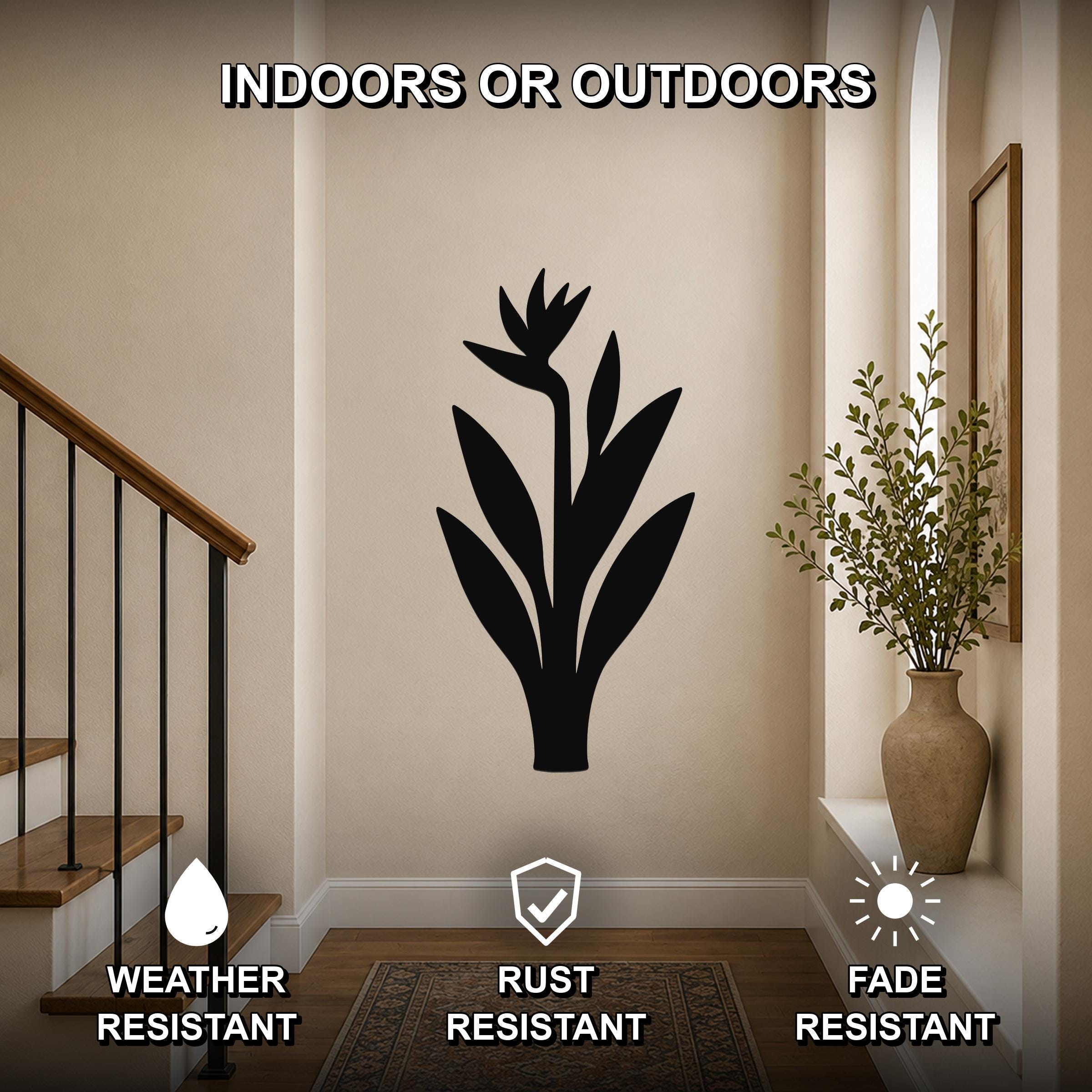 Black metal Bird of Paradise wall art silhouette mounted on a hallway wall near a staircase and a vase with greenery, suitable for indoor or outdoor use.