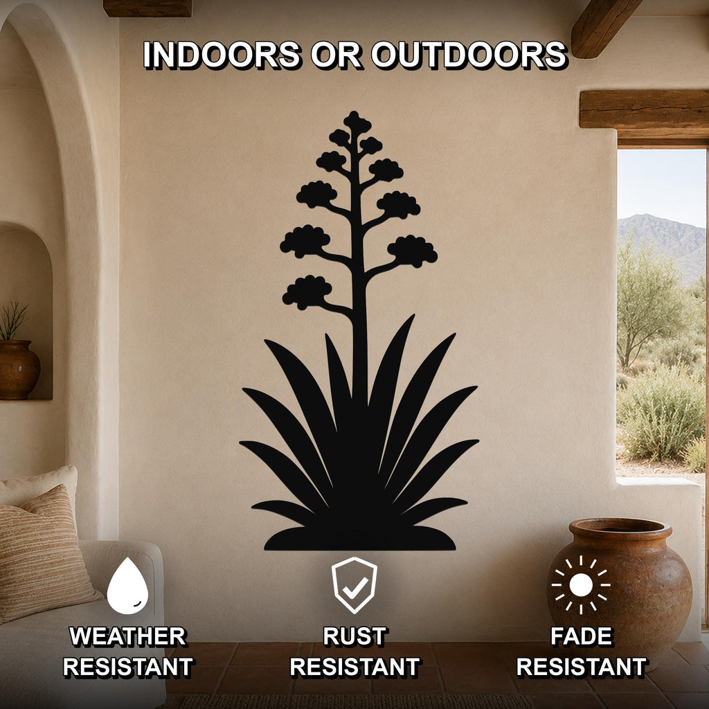 Black metal agave wall art with blooming flower cutout, mounted on a beige living room wall above a sofa, weather, rust, and fade resistant.