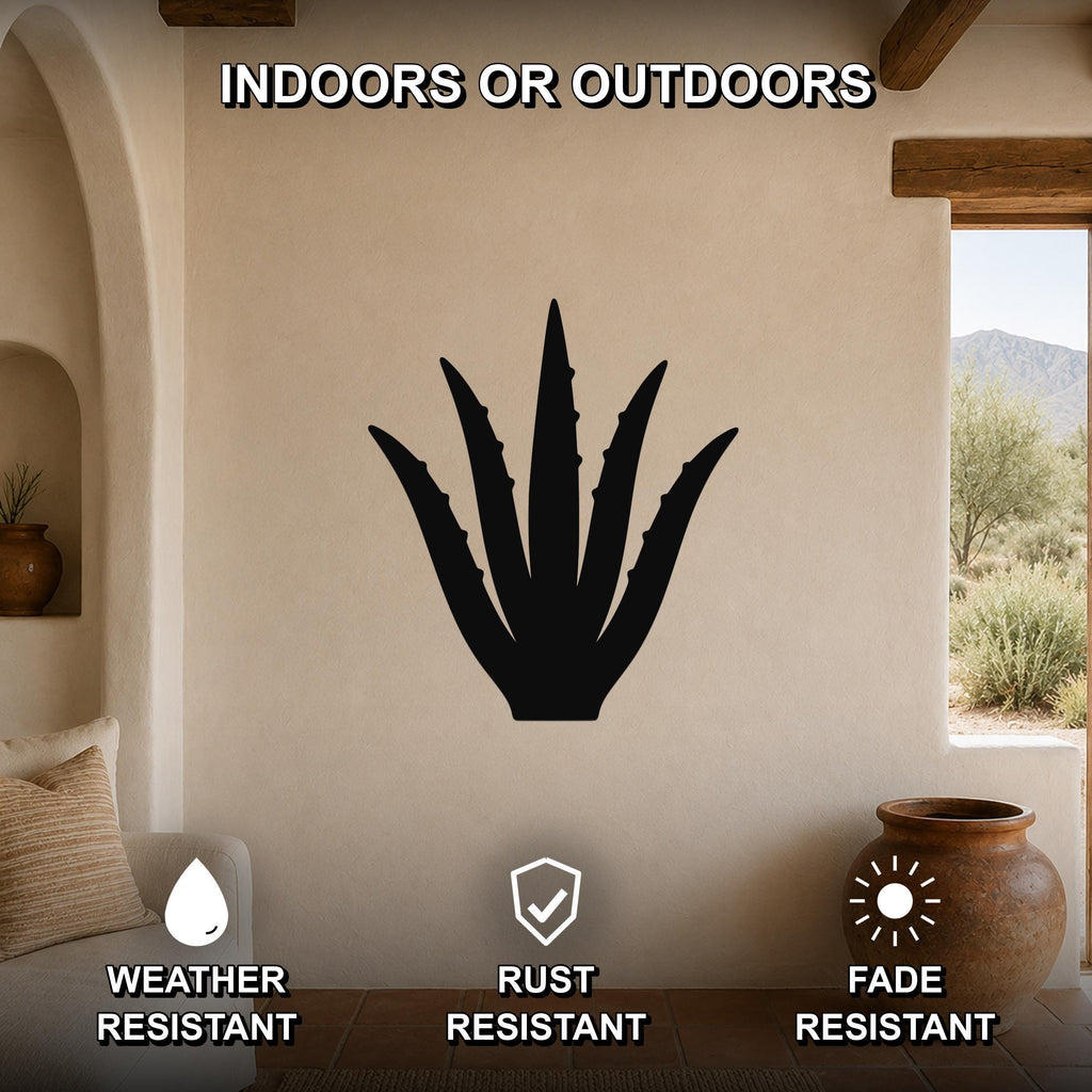 Black metal agave wall art silhouette mounted on a beige stucco wall in a living room with arched doorways and a view of mountains outside.