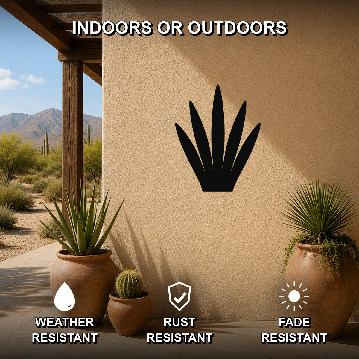 Black metal agave wall art silhouette mounted on a stucco outdoor wall, displayed above potted desert plants on a patio with mountains in the background.
