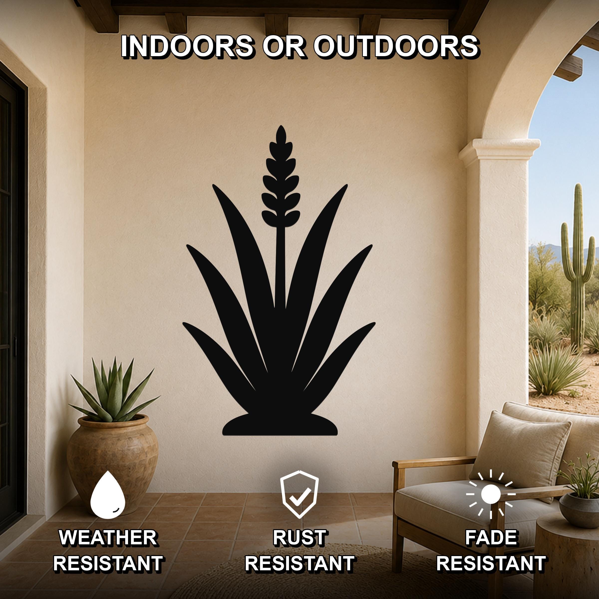 Black metal agave wall art with a tall flower spike cutout, mounted on a beige outdoor patio wall above a wooden chair.