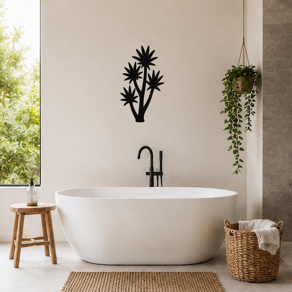 Black metal wall art in a tall yucca silhouette with multiple star-shaped leaf cutouts, mounted on a bathroom wall above a freestanding tub.