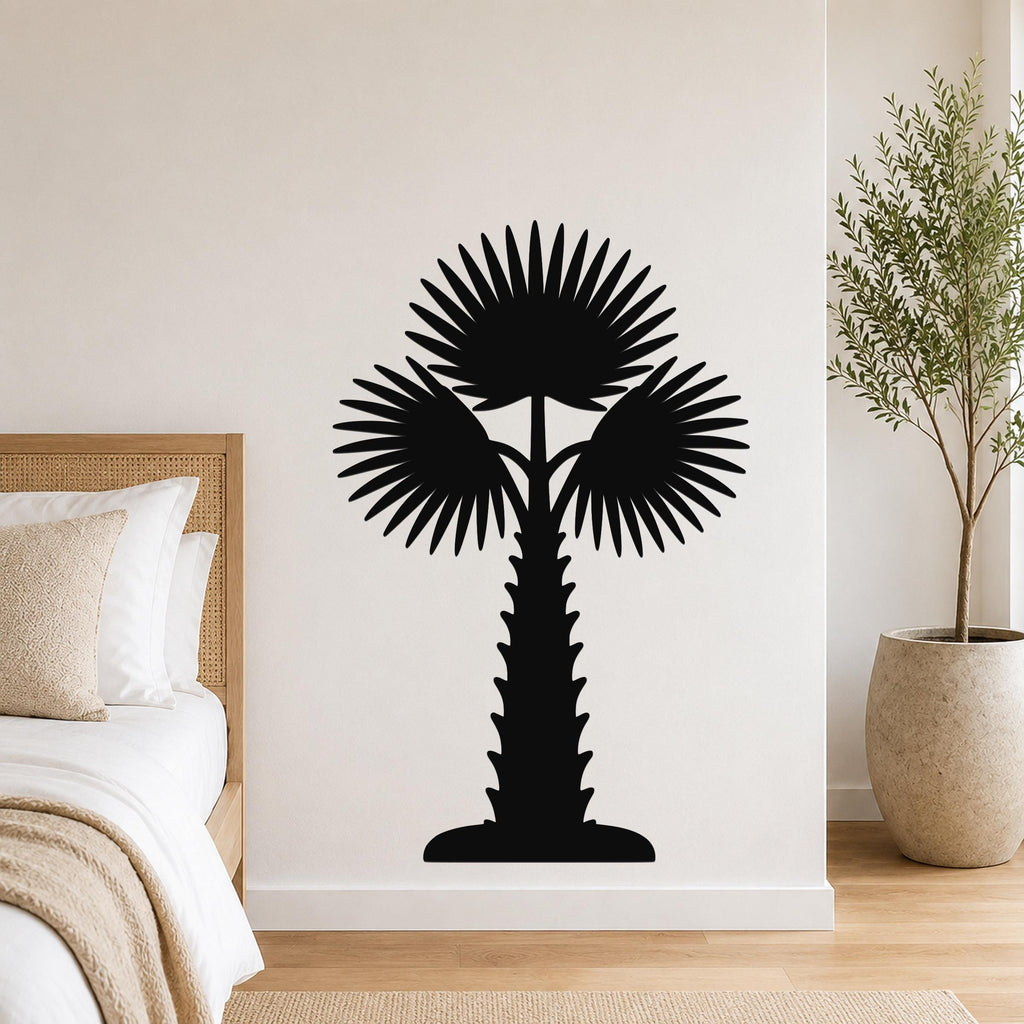 Black metal palm tree wall art with fan-shaped fronds and a textured trunk, mounted on a wall above a bed in a modern bedroom.