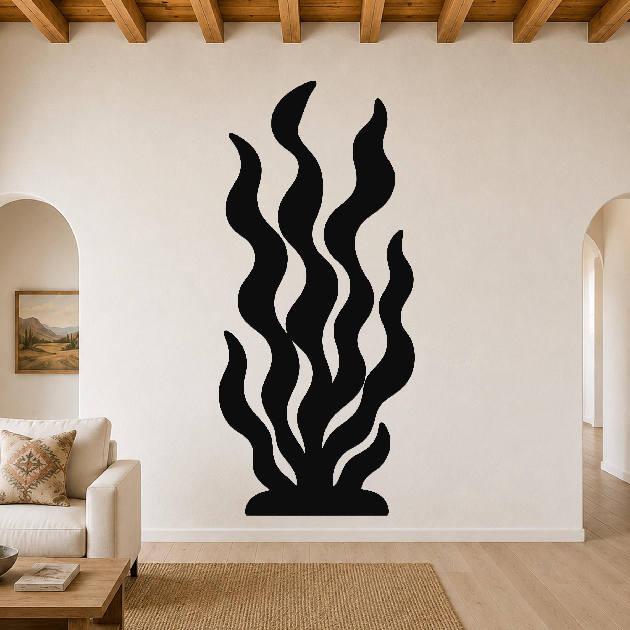 Black metal kelp wall art with wavy cutout design, mounted on a living room wall above a sofa.