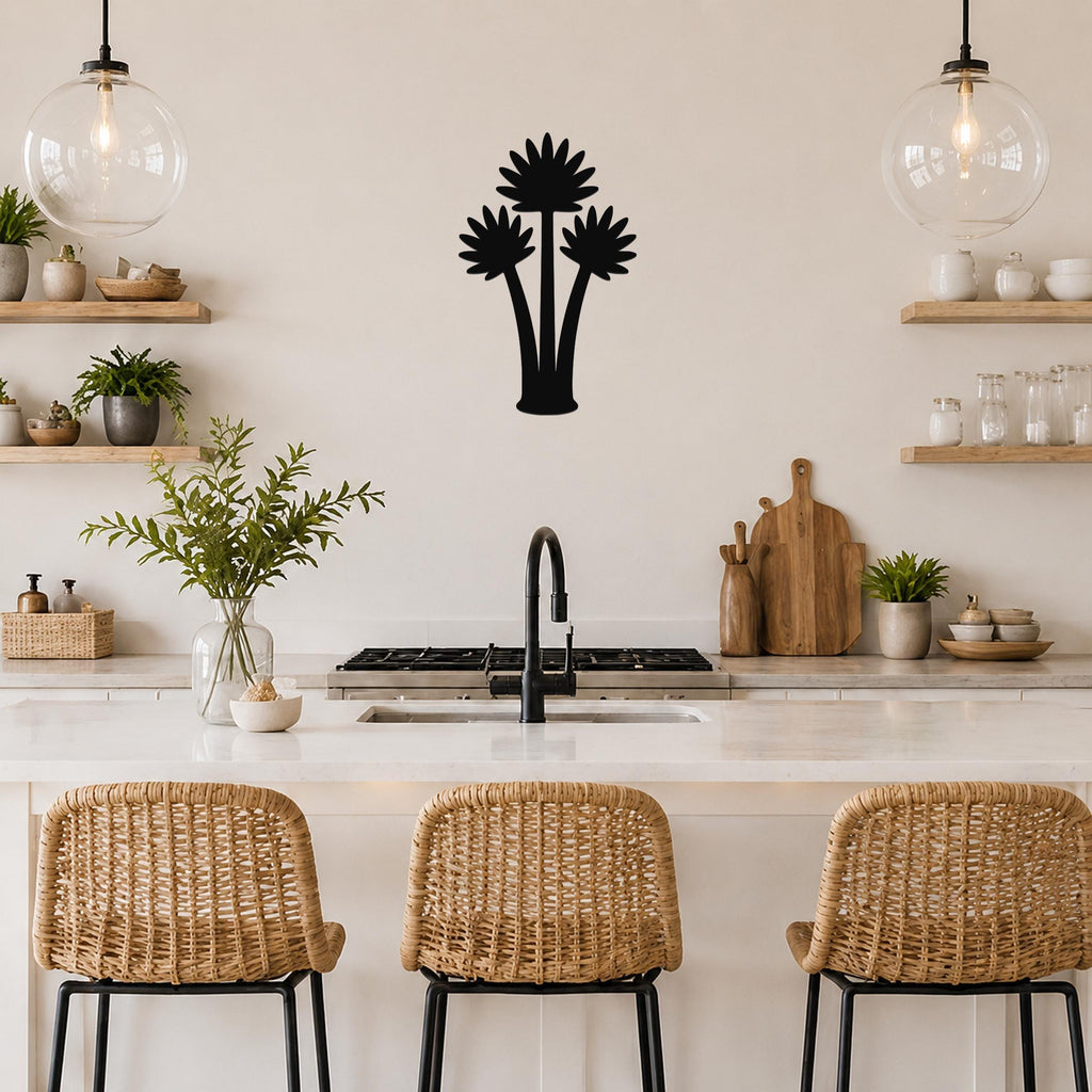 Black metal fan palm tree wall art with three distinct frond silhouettes, mounted on a kitchen wall above a white countertop.