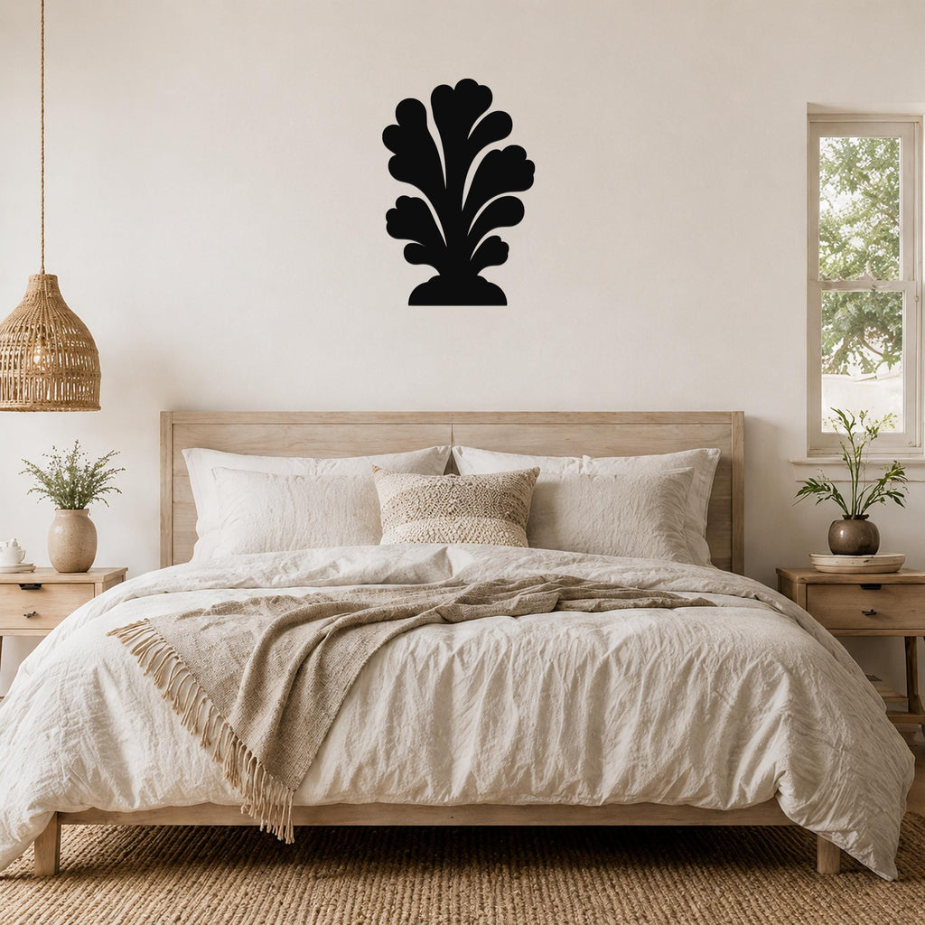 Black metal wall art in a coral or leaf-like silhouette, mounted above a bed in a neutral bedroom.