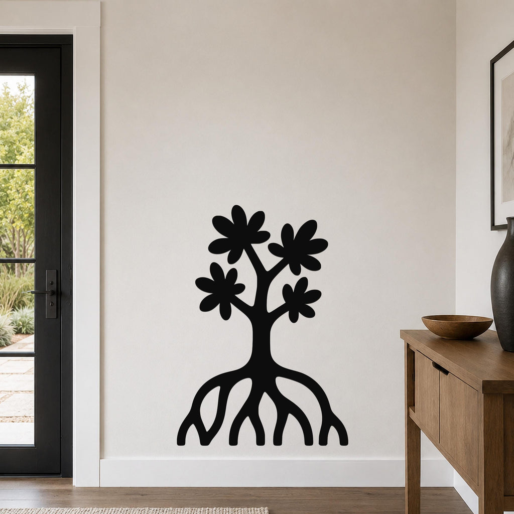 Black metal wall art cutout of a tree with blossoms and visible roots, mounted on a wall in a living room near a door and console table.