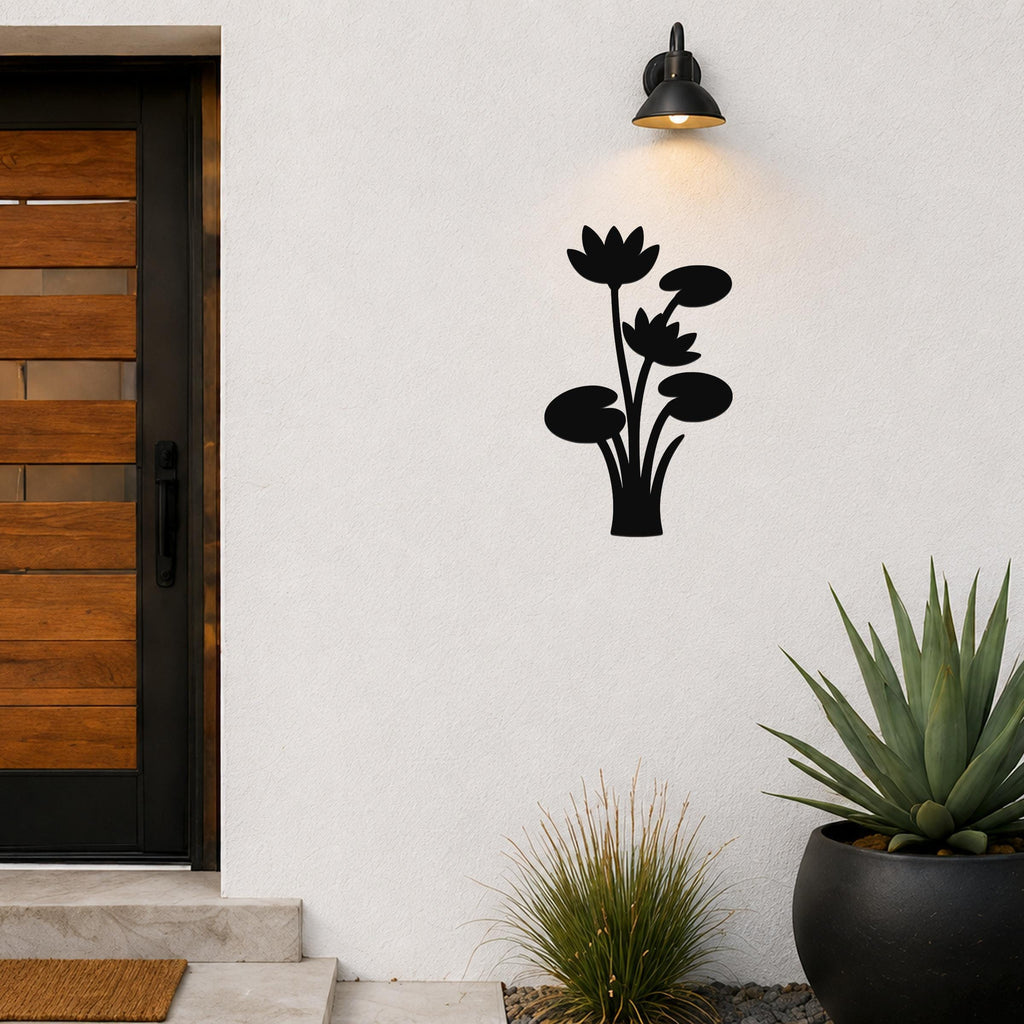 Black metal lotus and water lily wall art with cutout flowers and leaves, mounted on a white exterior wall above a potted succulent and near a front door.