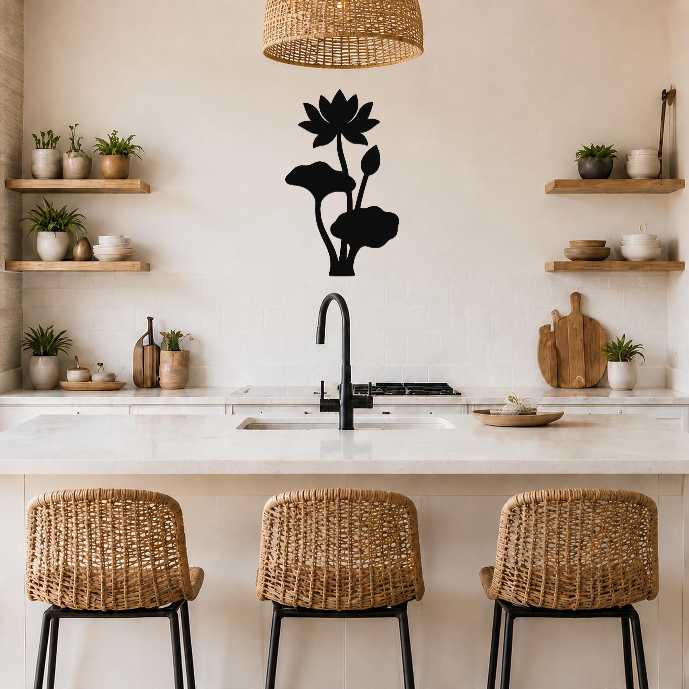 Black metal lotus flower wall art with leaf and bud cutouts, mounted on a kitchen wall above a counter.