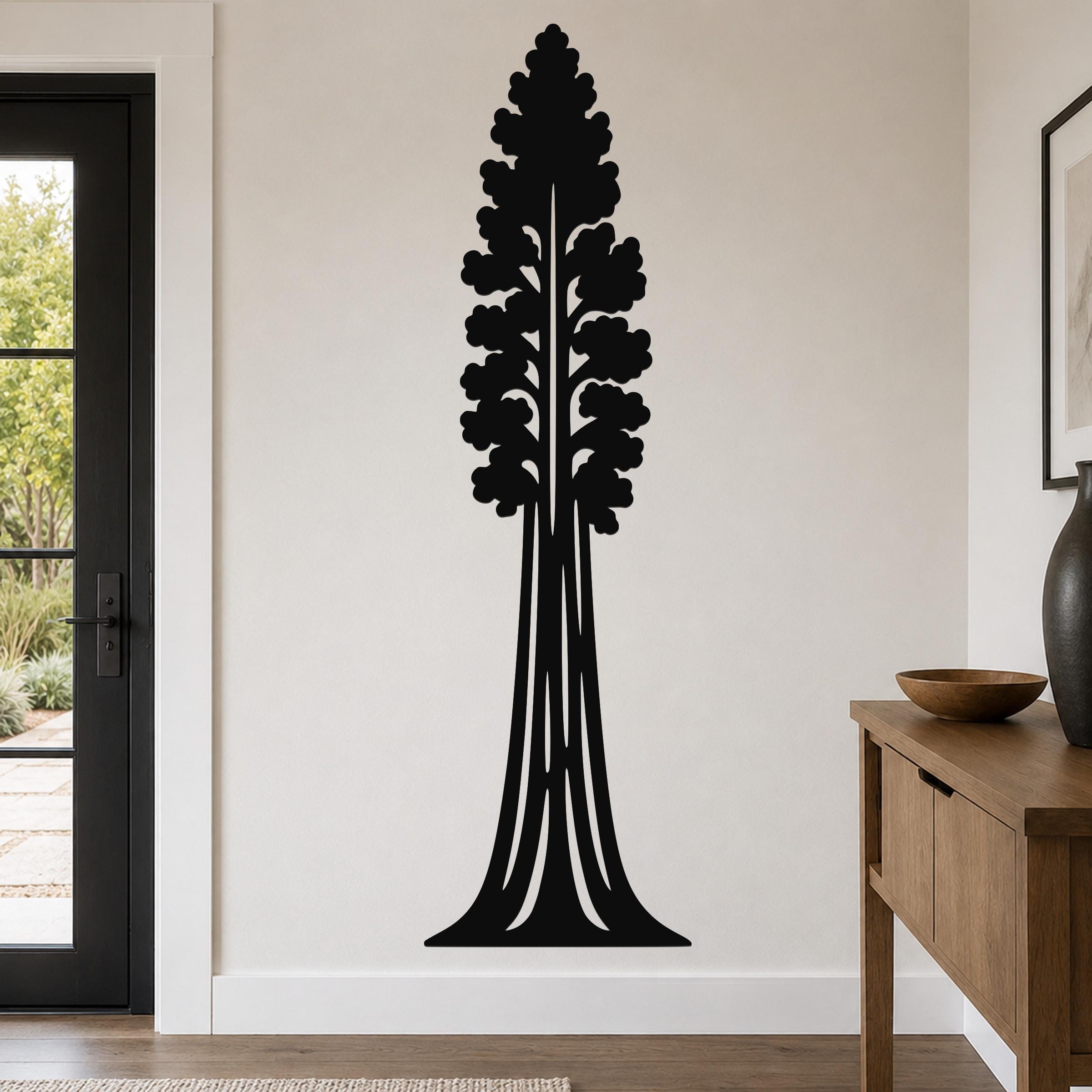 Black metal wall art in the silhouette of a sequoia tree with detailed branch cutouts, mounted on a living room wall above a wooden console table.