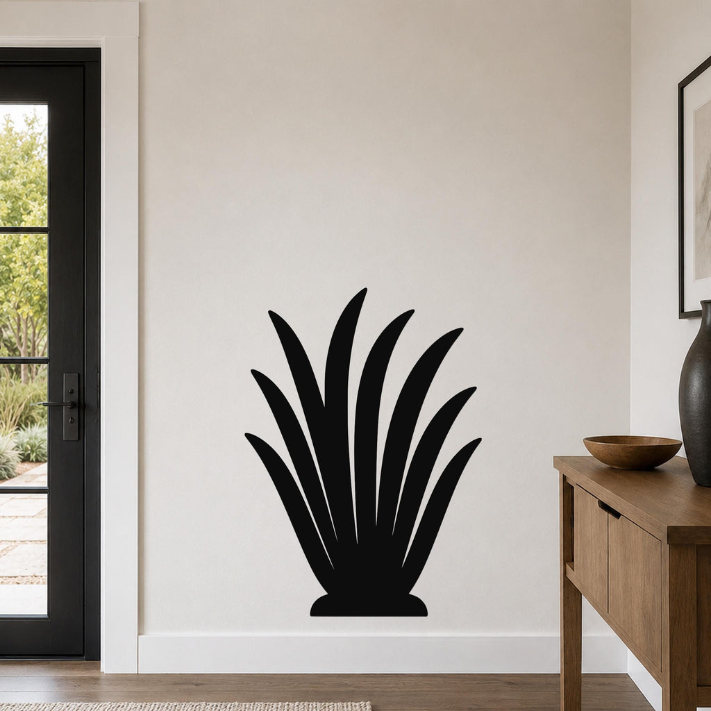 Black metal wall art in a silhouette of a spiky agave plant, mounted on a light-colored wall in a modern entryway.
