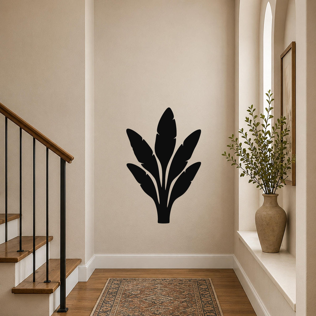 Black metal banana plant wall art with leaf cutouts, mounted on a hallway wall above a patterned rug near a staircase.