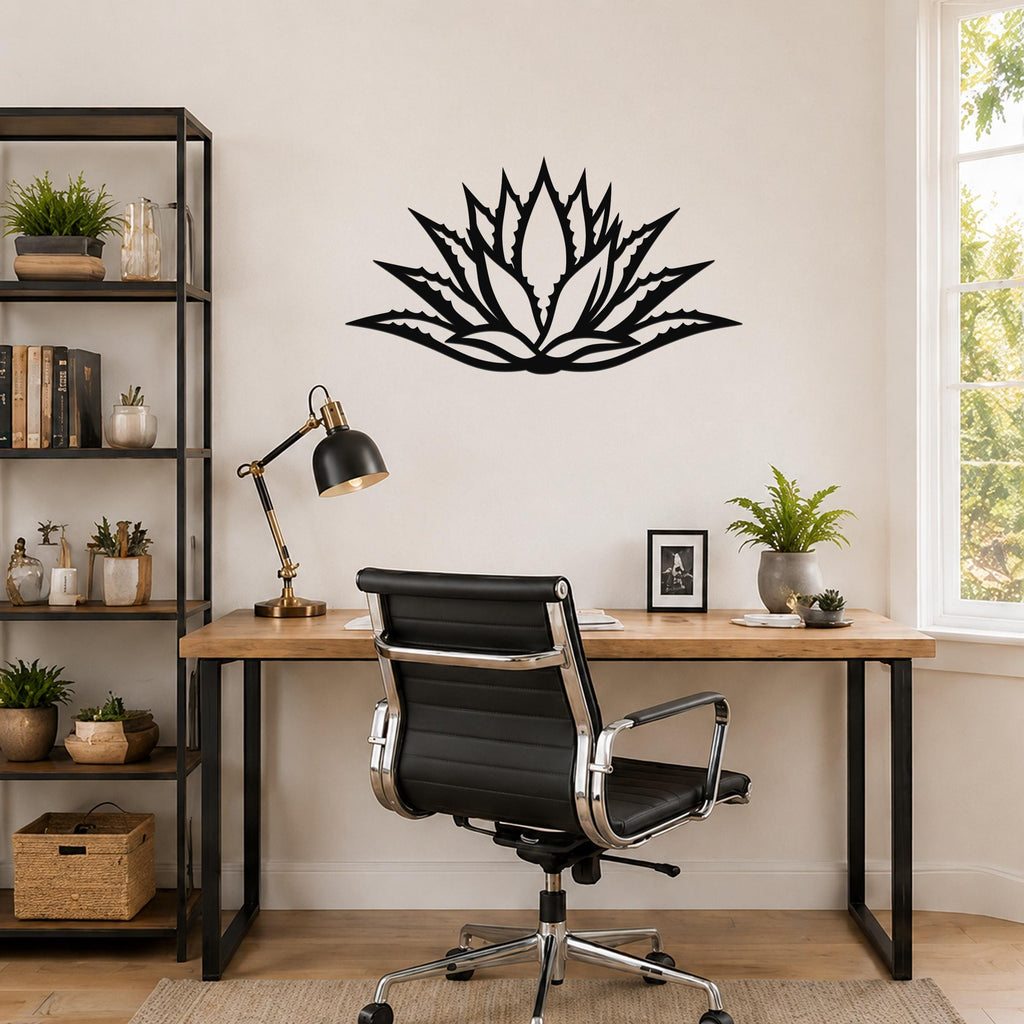 Black metal agave wall art with a bold geometric cutout design, mounted on a wall above a wooden desk in a home office.