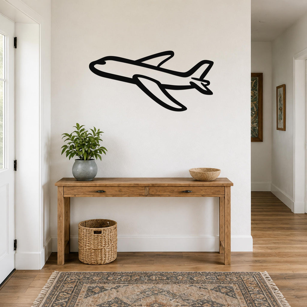 Black metal airplane wall art with a bold silhouette design, mounted on a white wall above a wooden console table in a hallway.