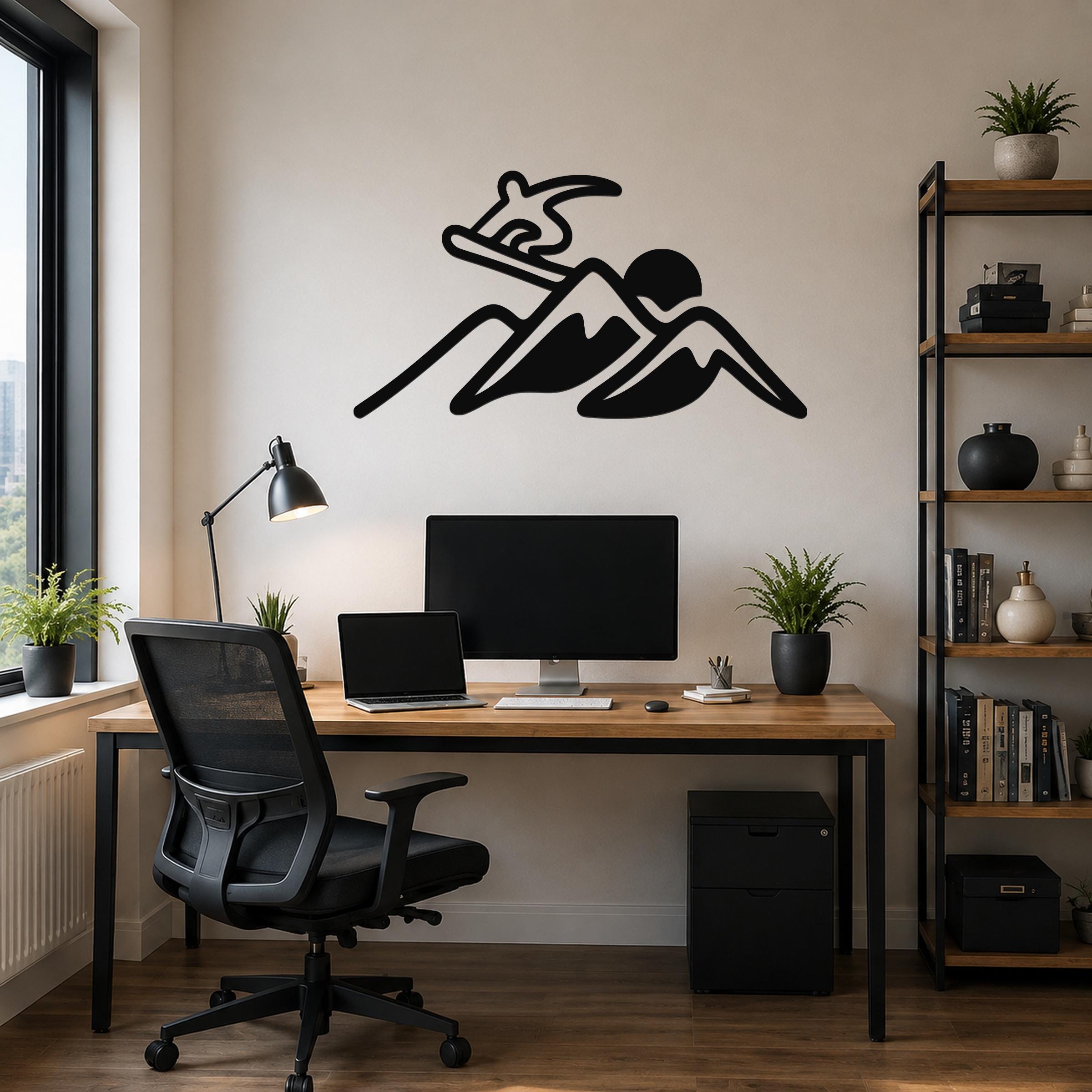 Black metal wall art silhouette of a snowboarder above a desk in a home office.