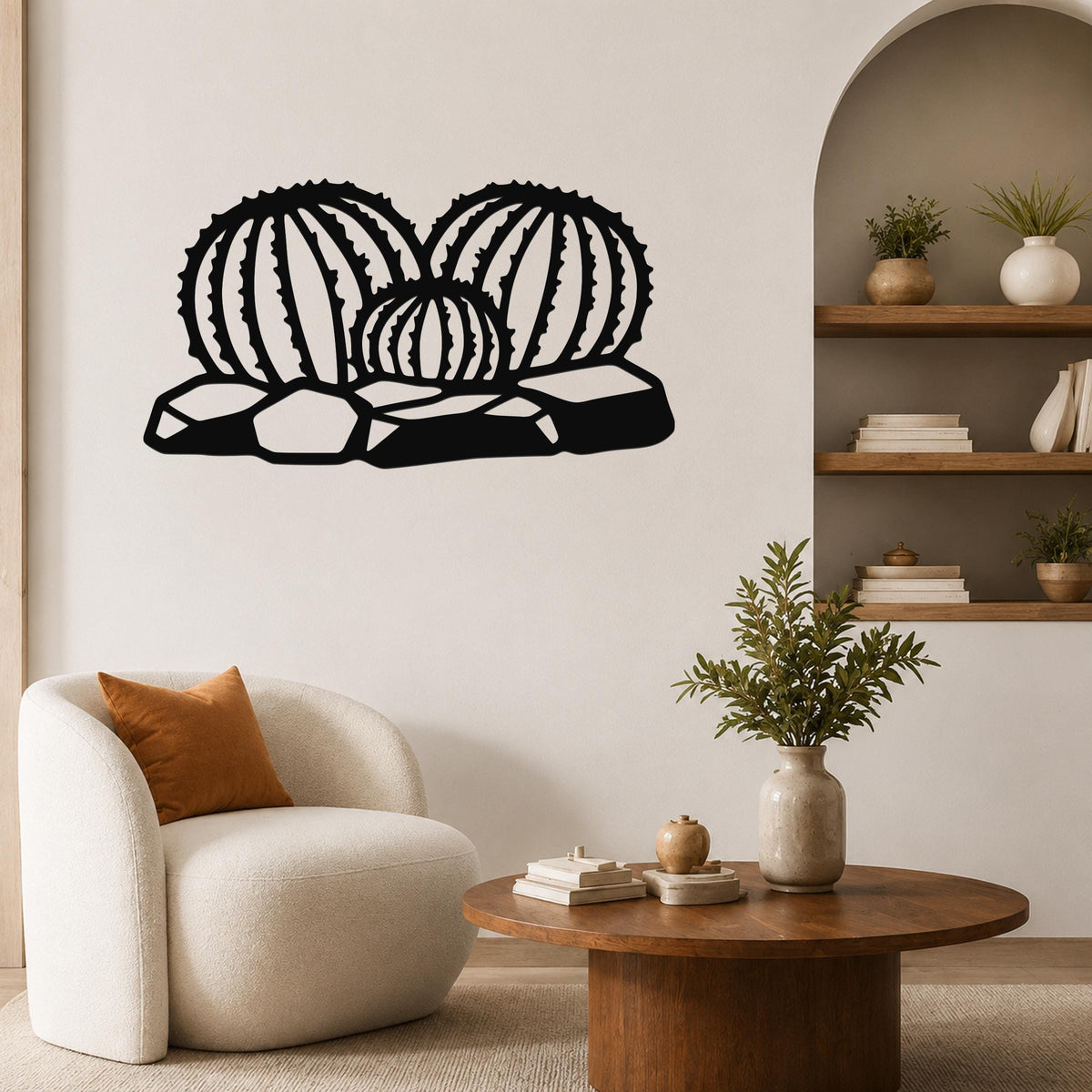 Black metal barrel cactus wall art with ribbed cutouts, mounted on a living room wall above a white armchair.