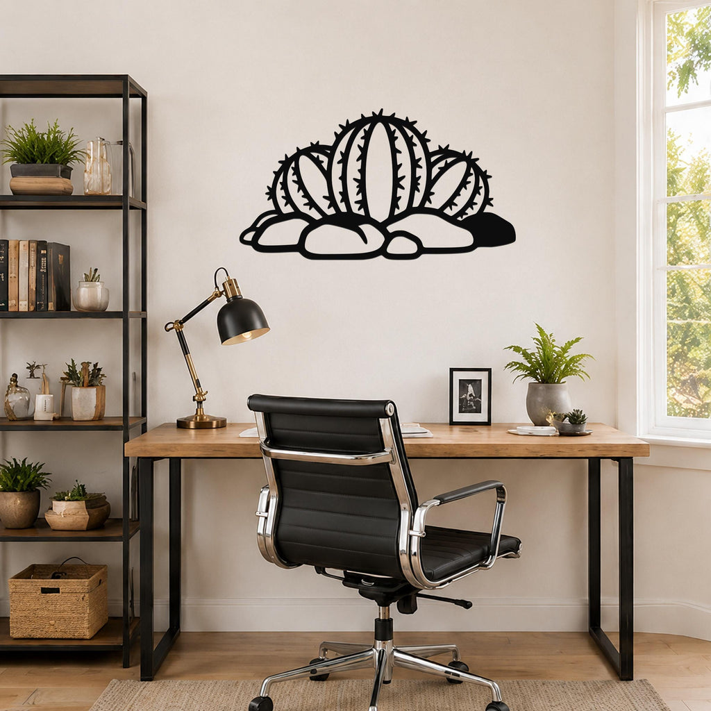 Black metal barrel cactus wall art with spines and rocks cutout, mounted above a wooden desk in a home office.