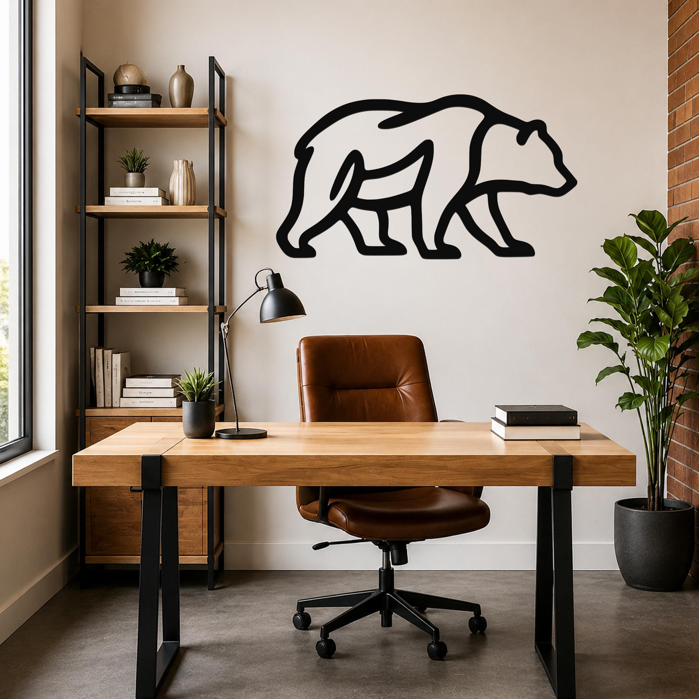Black metal bear silhouette wall art mounted on a light-colored wall above a wooden desk in a modern home office.