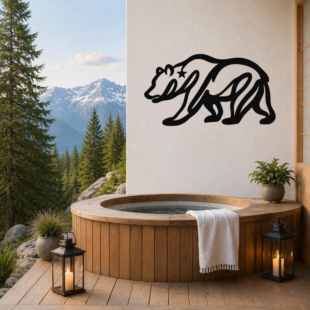 Black metal bear wall art with a star cutout, mounted on a white wall above a wooden hot tub on a mountain-view deck.