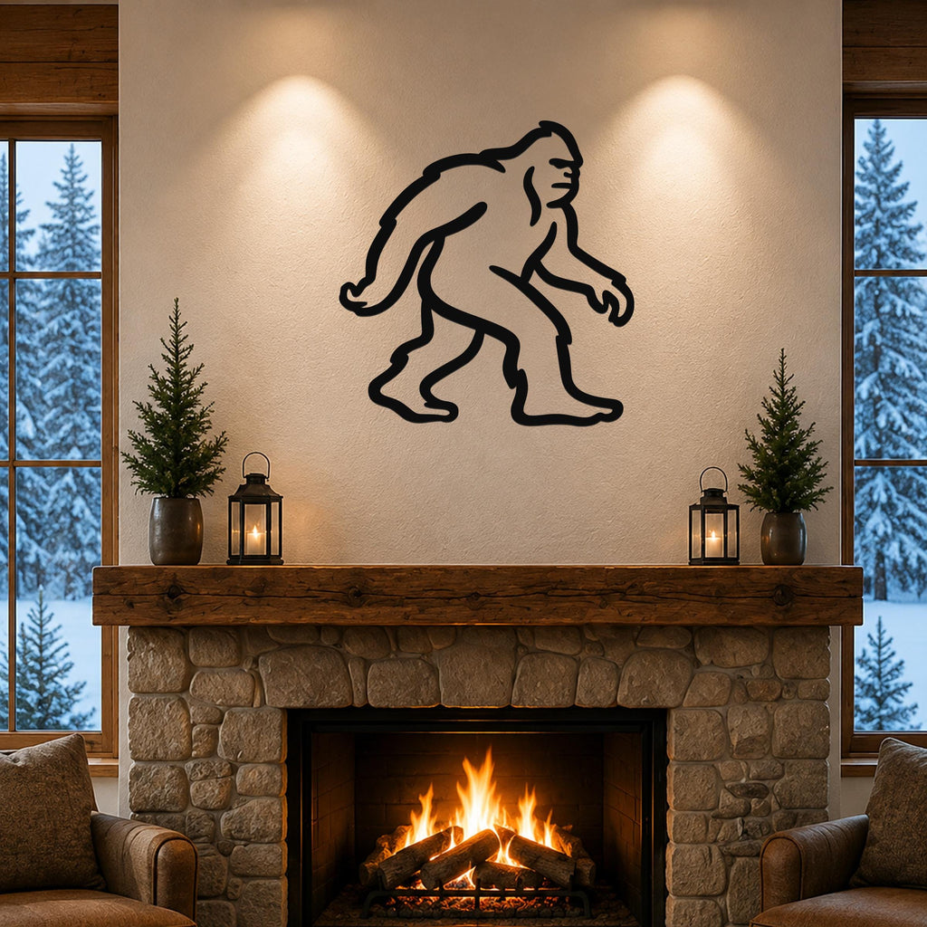 Black metal Bigfoot silhouette wall art mounted above a stone fireplace in a cozy living room with snow outside.
