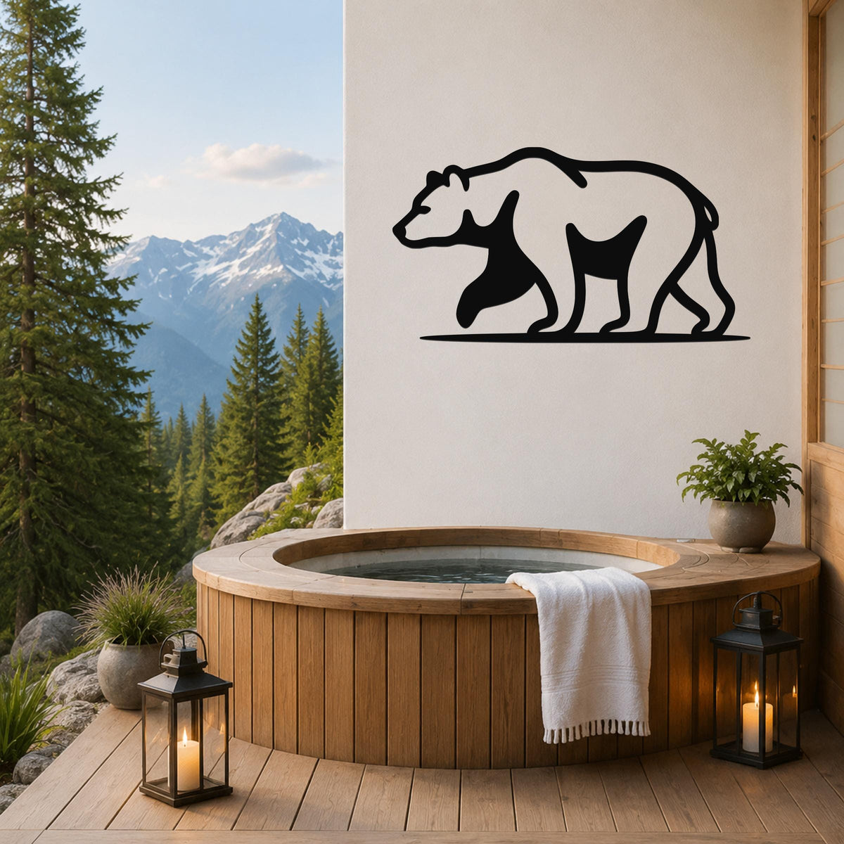 Black metal bear silhouette wall art mounted on a white wall above a wooden hot tub on a mountain-view deck.